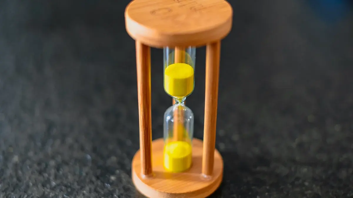 Wooden hourglass with yellow sand