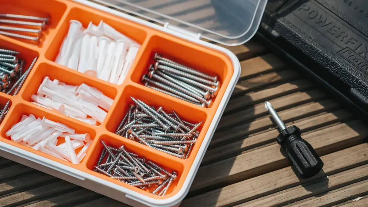 Open organizer of screws and anchors next to a screwdriver